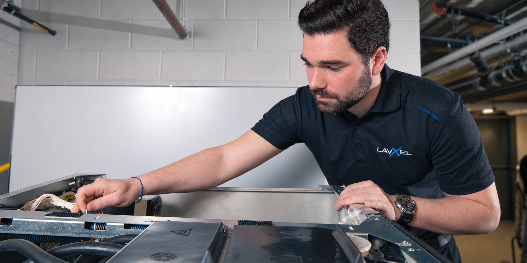 LavXel technician receiving hands-on training on laundry equipment